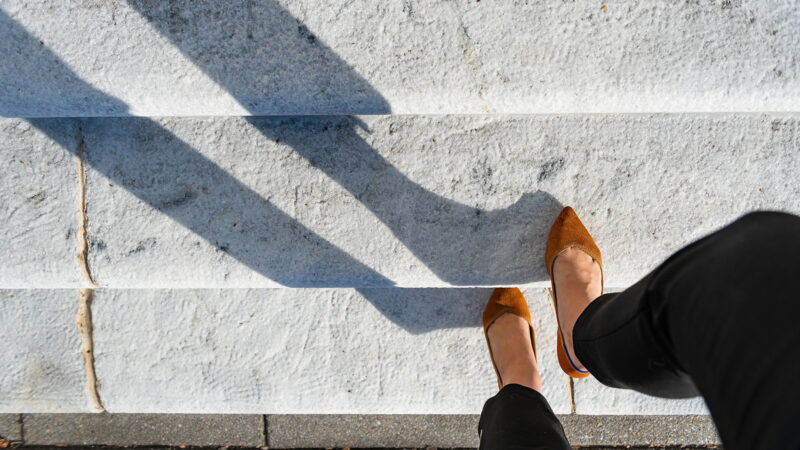 female employee walking up white marble stairs staircase